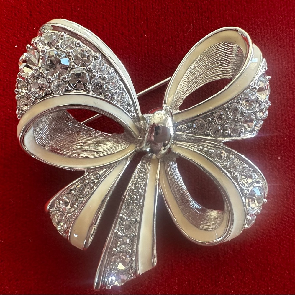 Gorgeous Nolan Miller white enamel and silver bow pin. Stunning holiday piece.
